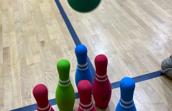  Image of bowling pins with the bowling ball flying toward them